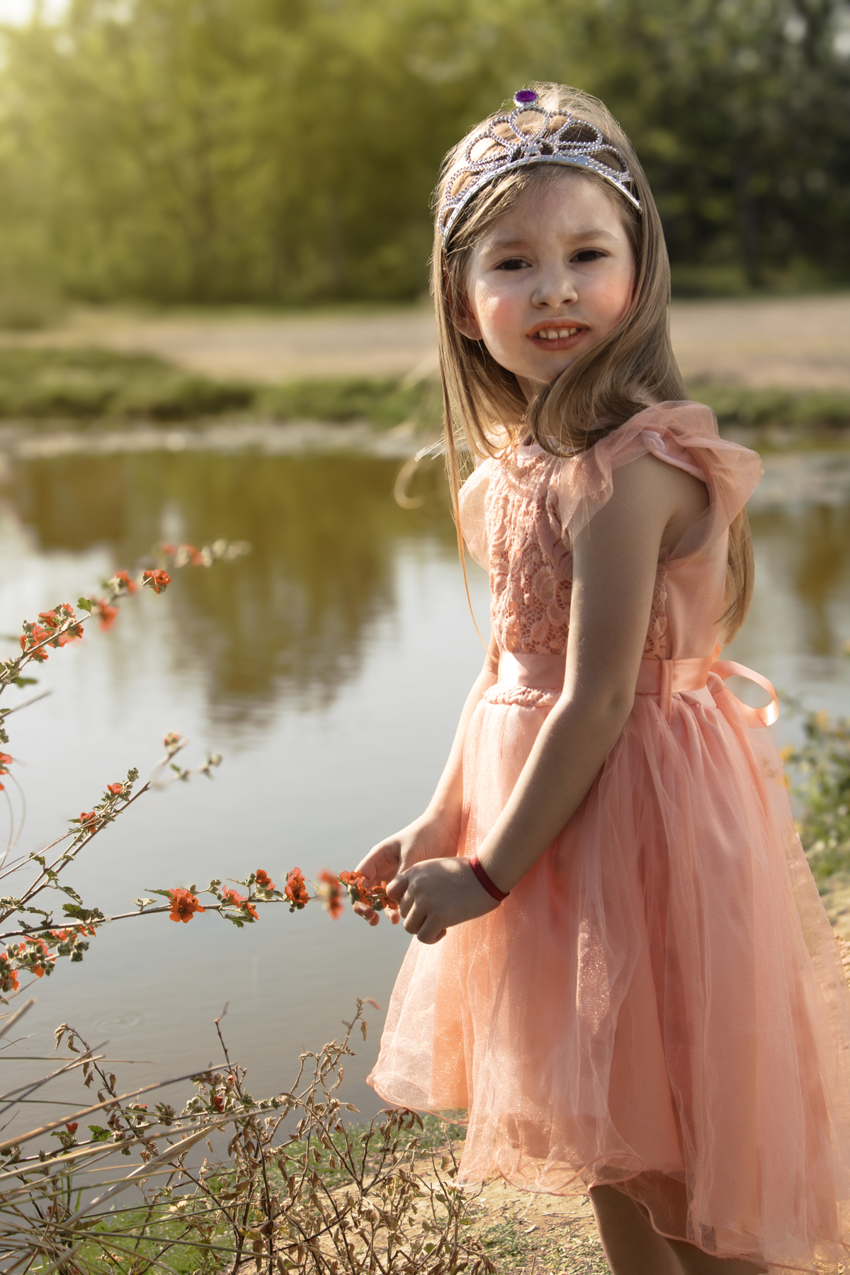 Niña en el bosque junto a un lago