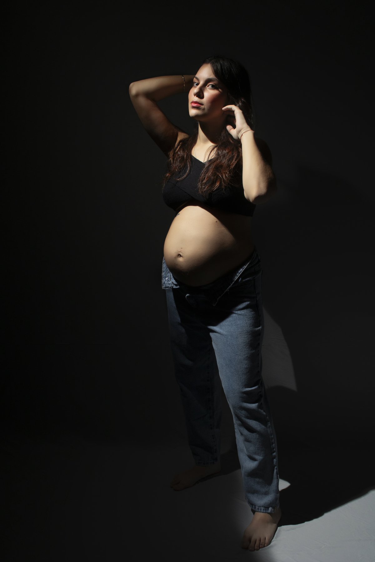 embarazada con ropa informal fondo oscuro