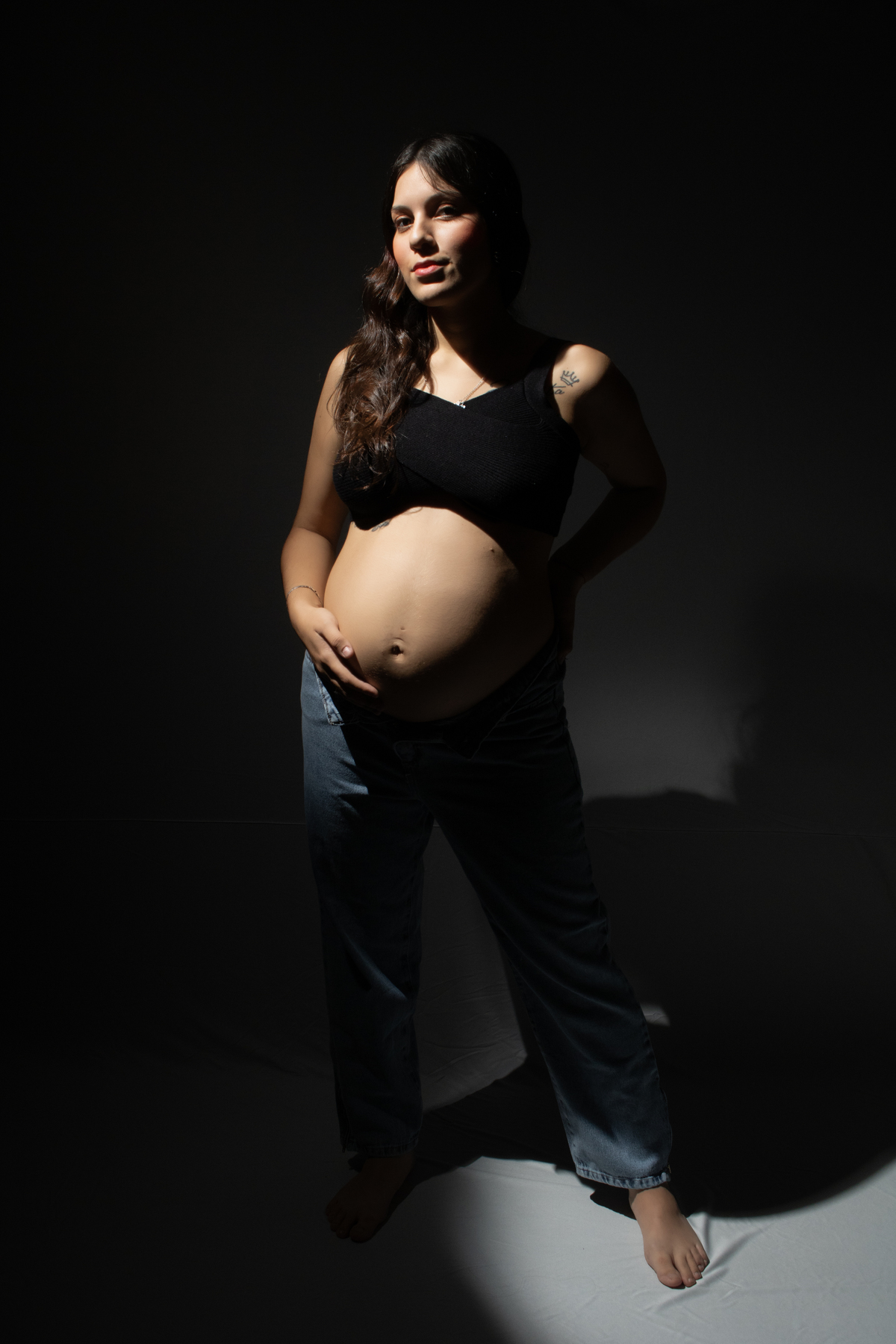 embarazada con ropa informal fondo oscuro