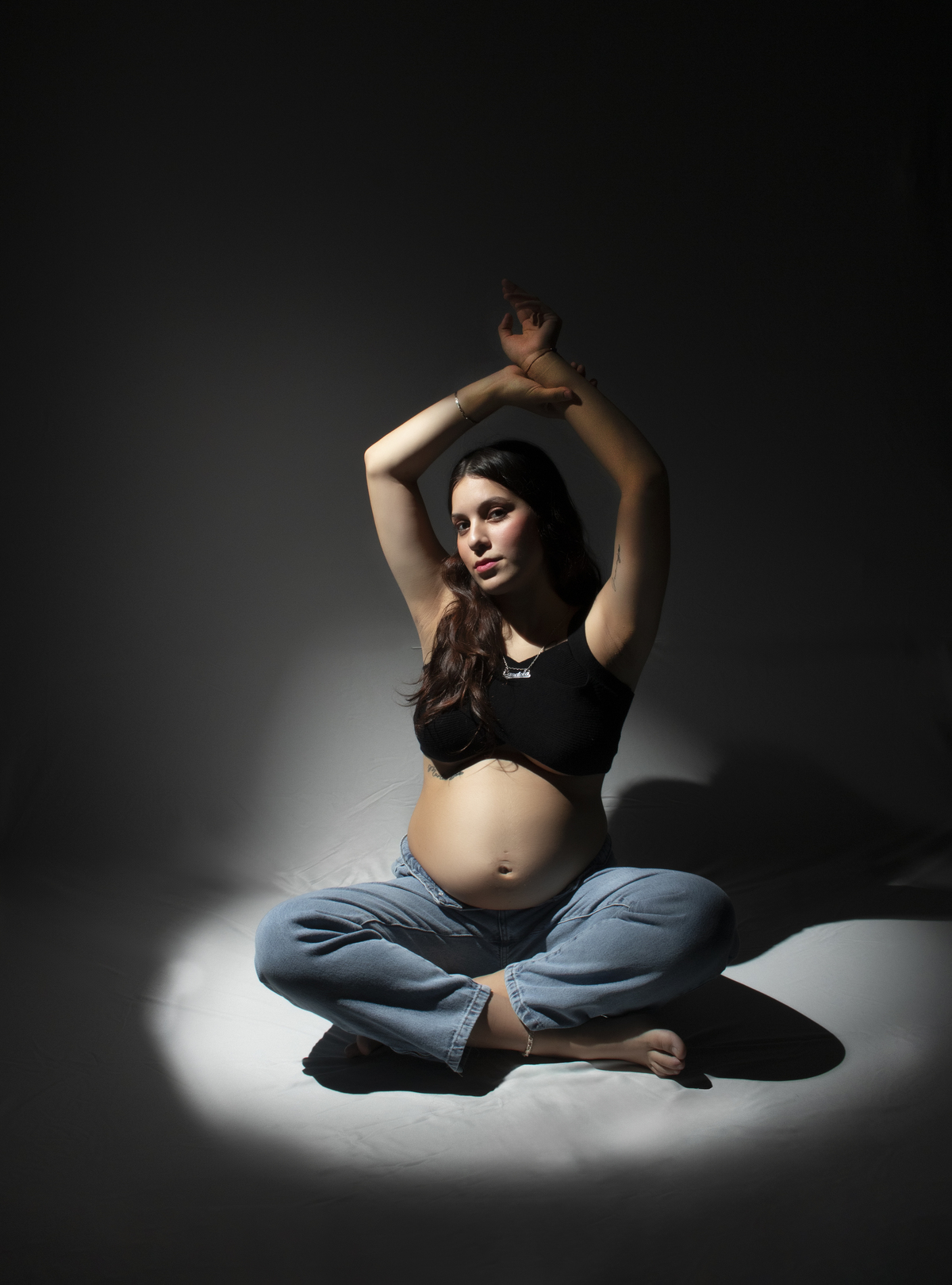 embarazada con ropa informal sentada sobre el piso