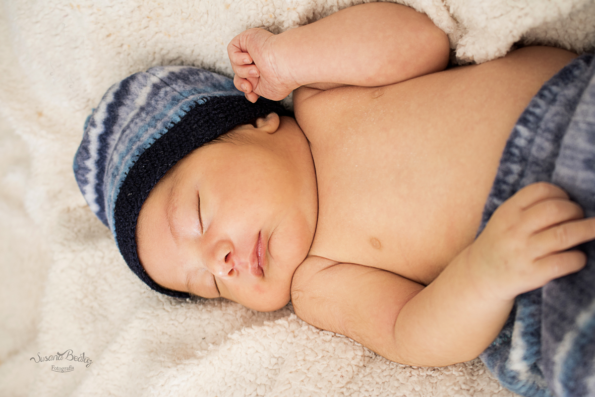 bebe desde la cintura con pantaloncito y gorrito celeste, azul y blanco