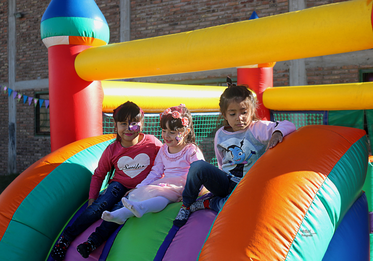 niñas jugando en tobogan de pelotero
