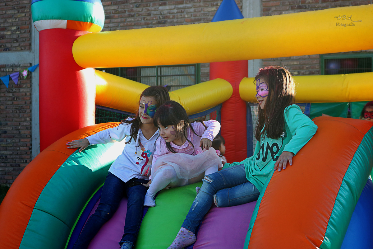 niñas jugando en tobogan de pelotero