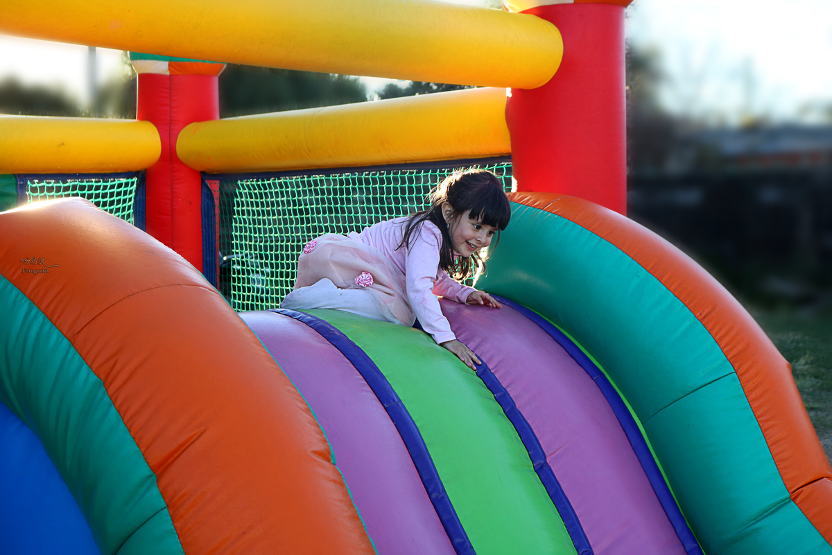 niña jugando en tobogan de pelotero