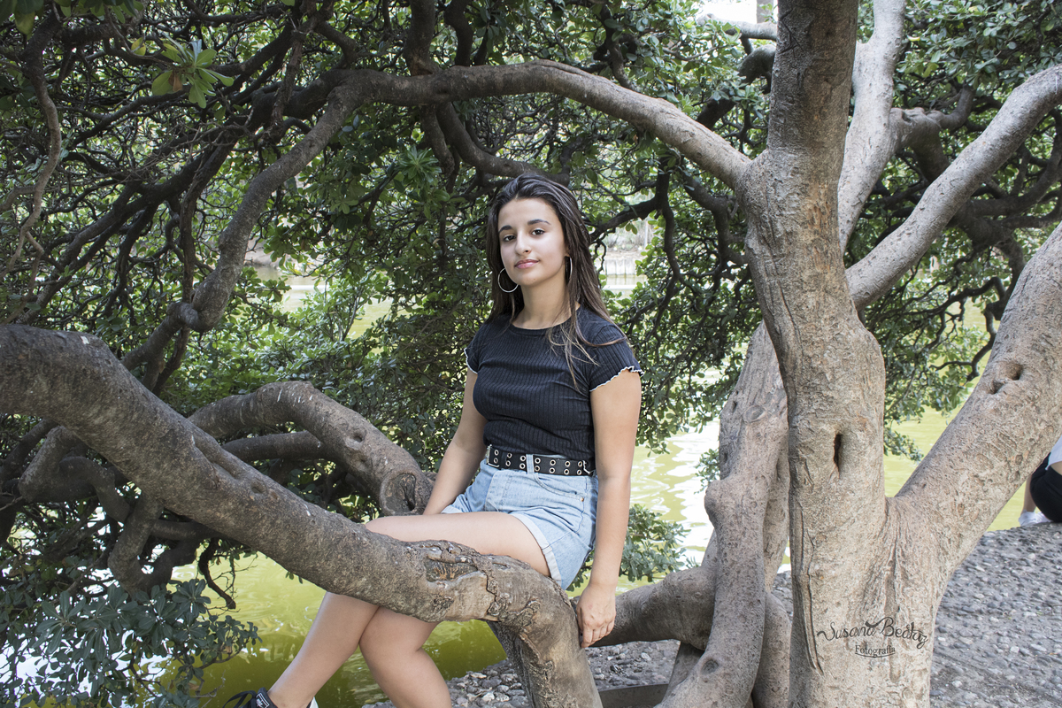 plano general quinceañera entre las ramas de un árbol