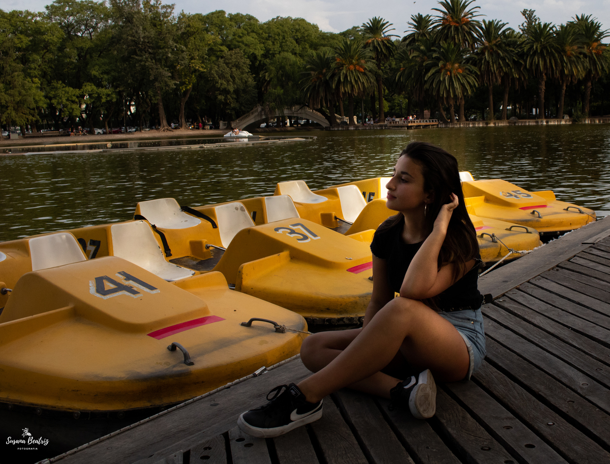 plano general quinceañera sentada en un muelle de bicicletas acuáticas