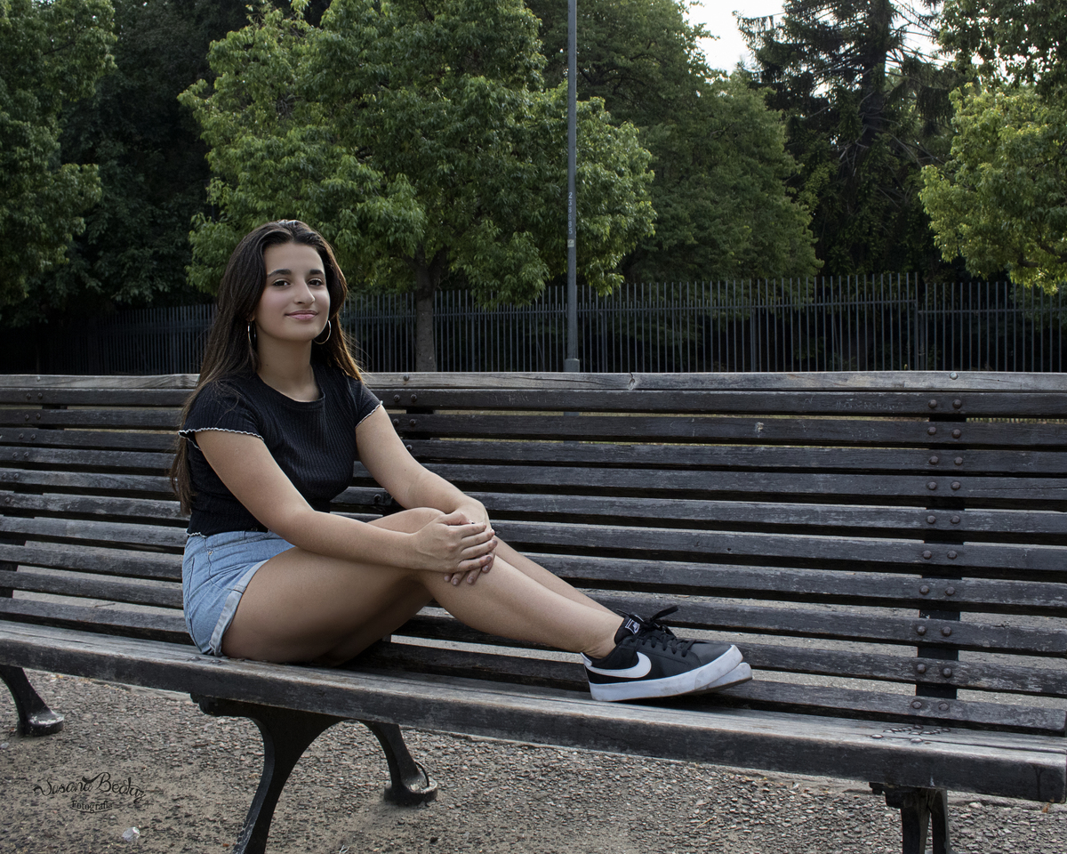 plano general quinceañera sentada en un banco del parque