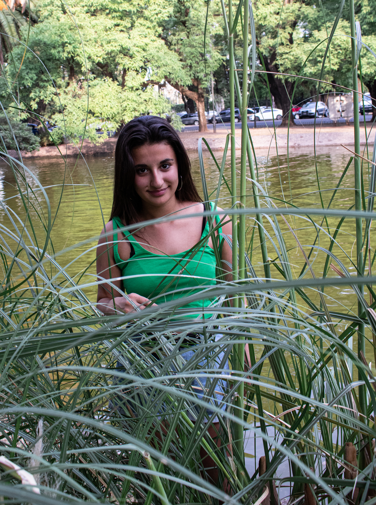 plano americano quinceañera detrás de las plantas