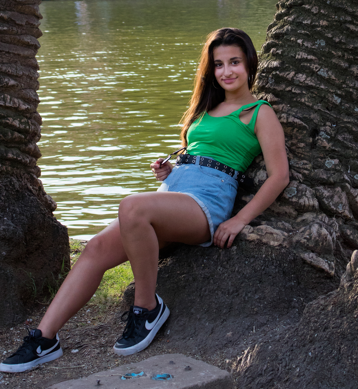 plano general quinceañera recostada sobre el tronco de una palmera