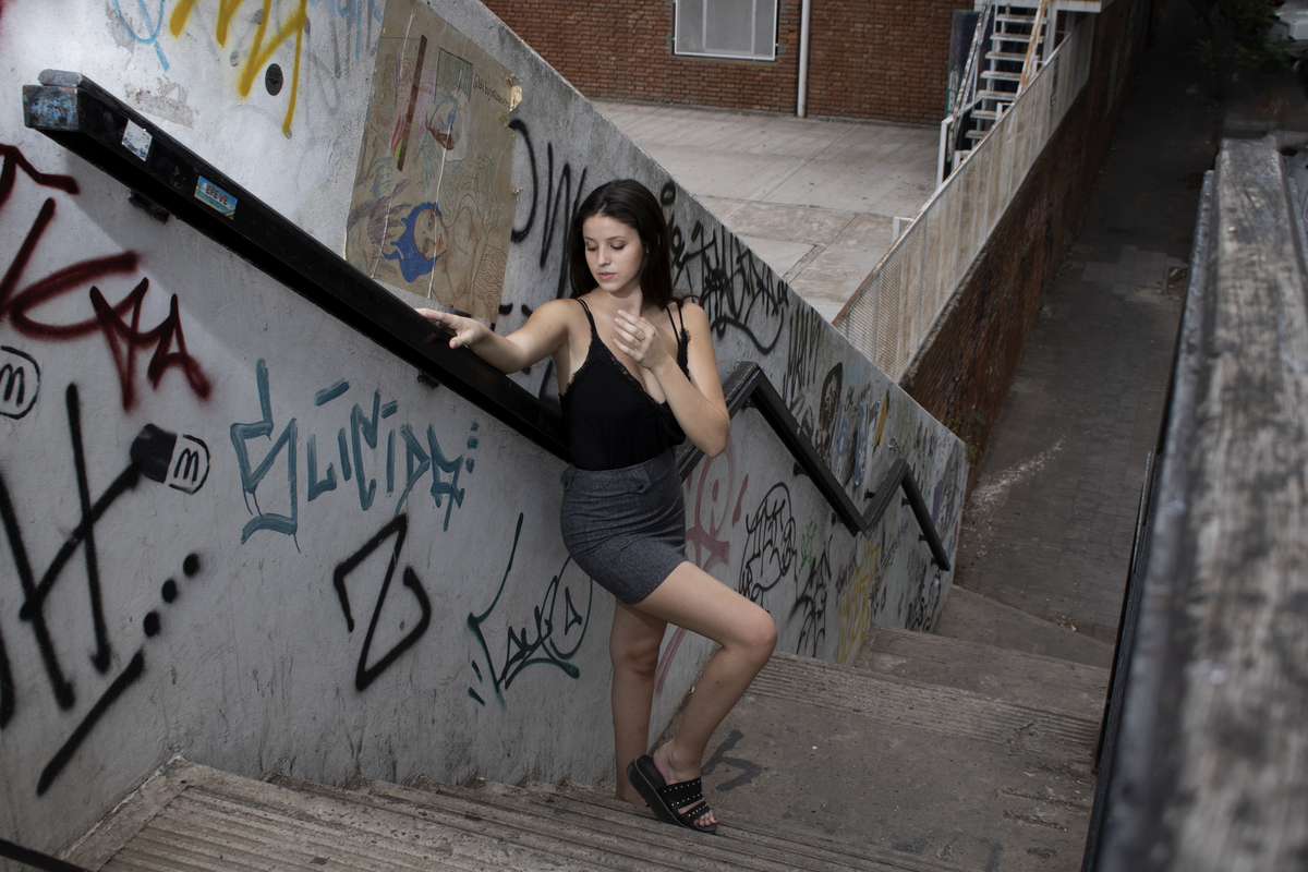 modelo plano general, falda gris, blusa negra, en escalera