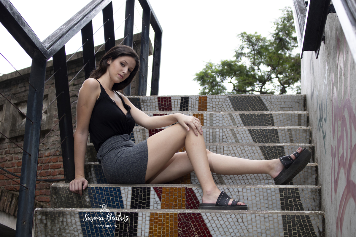 modelo plano general, falda gris, blusa negra en escalera