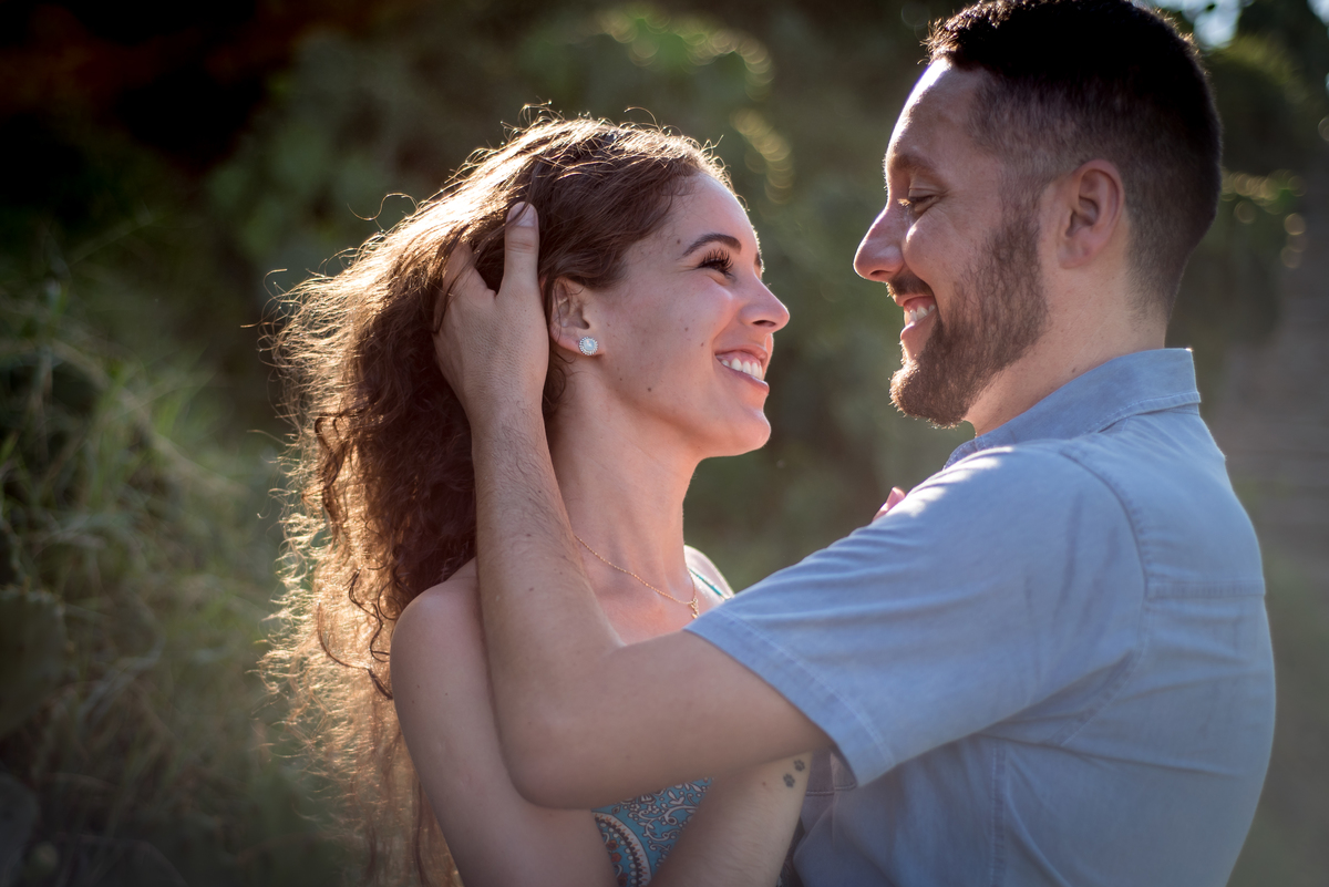Carol e Luis juntos e sorrindo sb a luz do Arpoador
