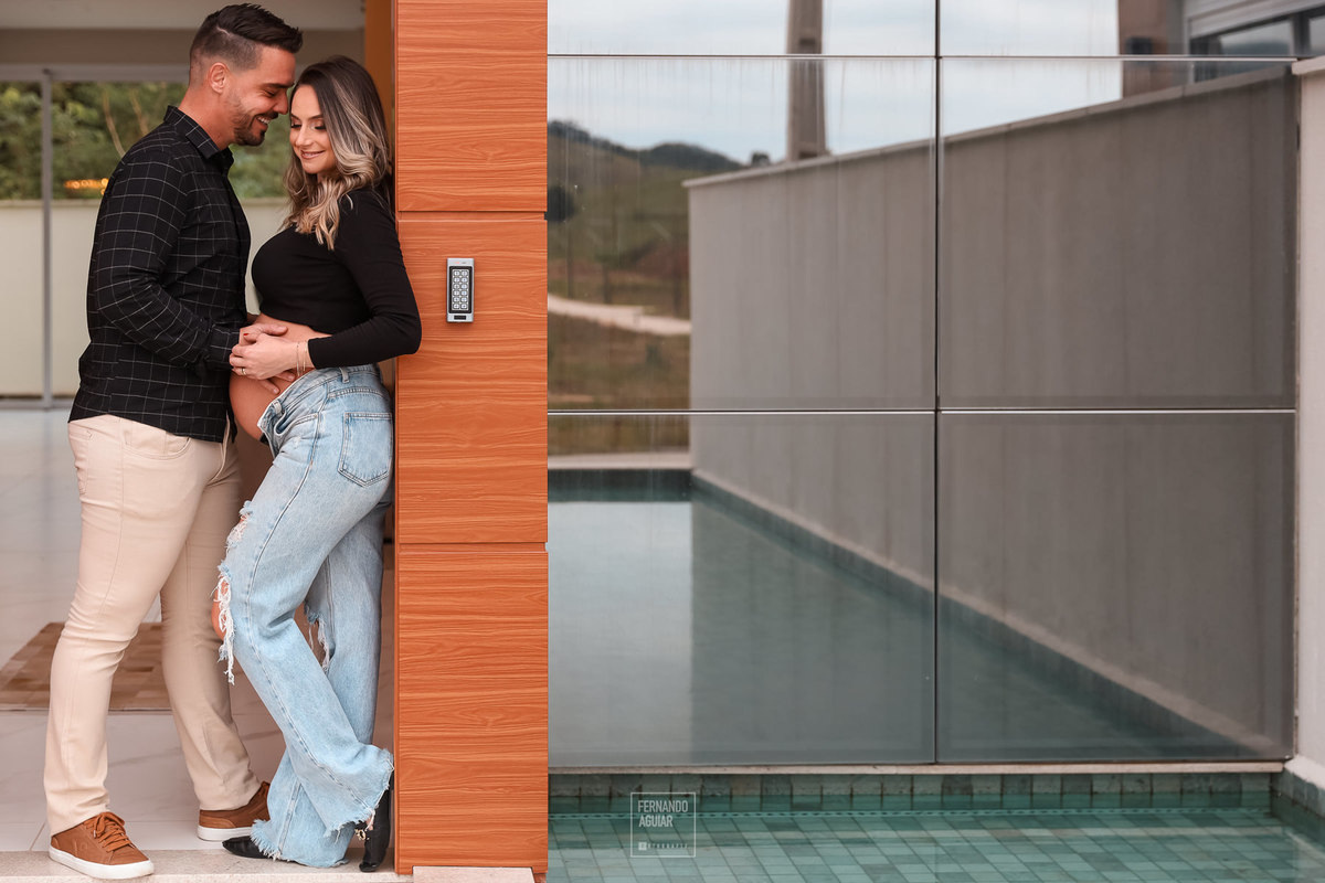 Casal na porta de casa no ensaio gestacional