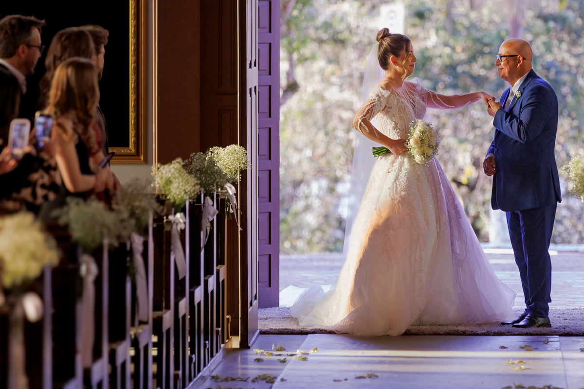 Entrada da noiva na igreja, pai beijando a mão da noiva