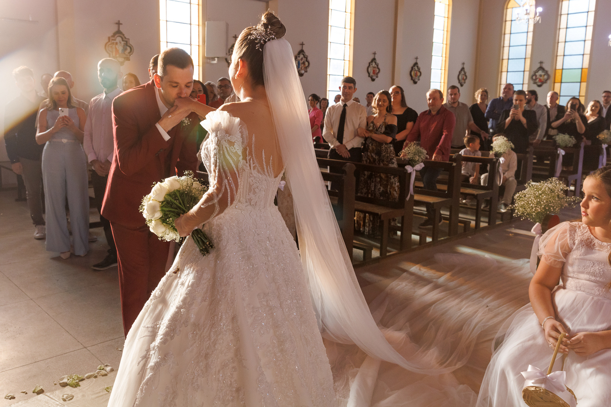 Noivos na igreja, noivo beijando a mão da noiva