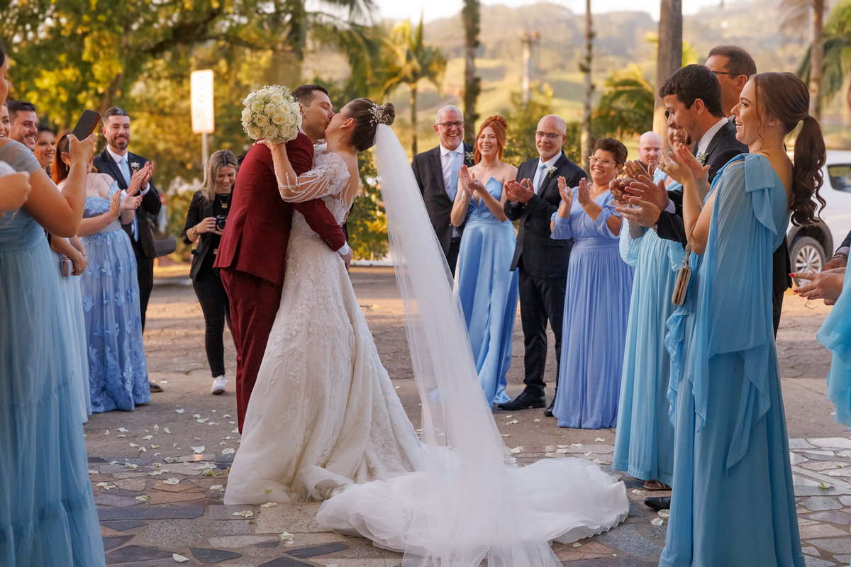 Beijo dos noivos na saída do casamento, padrinhos de casamento