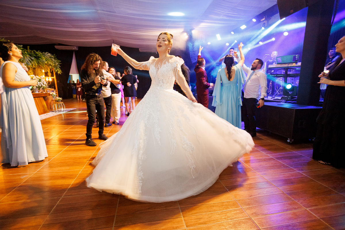 Registro encantador da noiva girando na pista de dança, mostrando a leveza e o movimento do vestido.