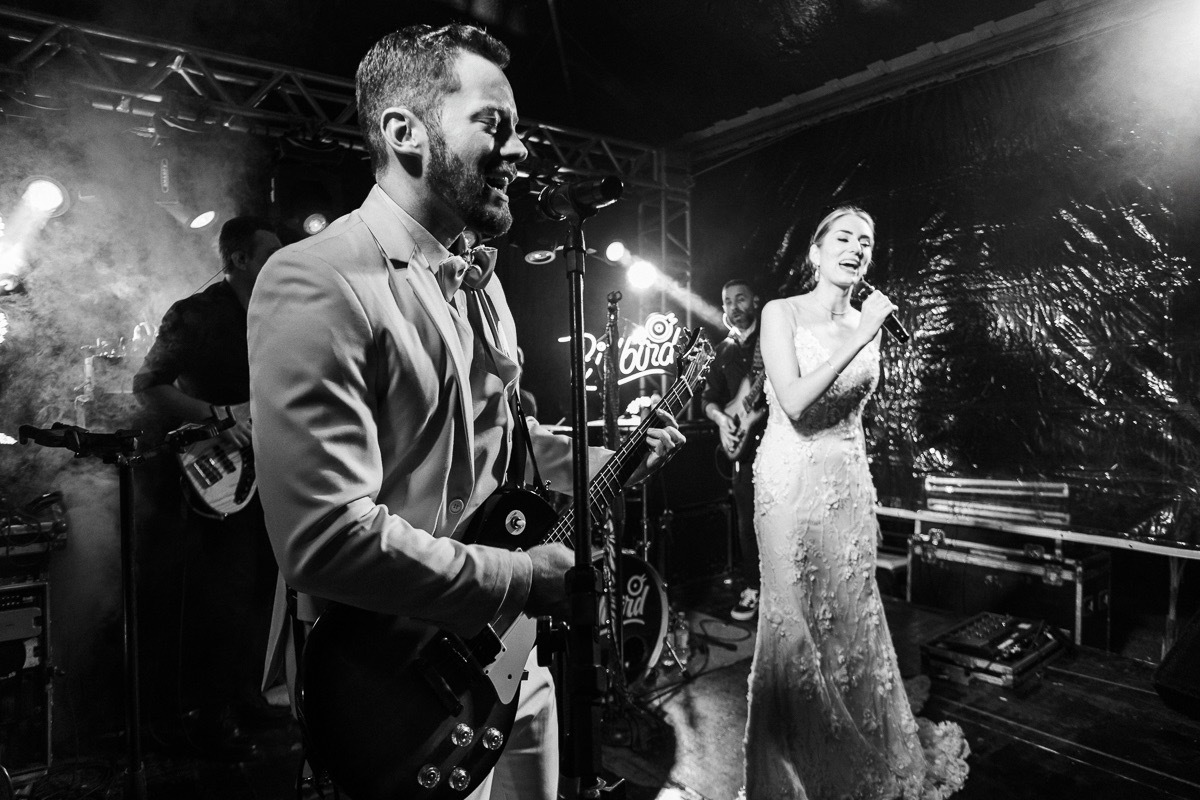 Noivos cantando e tocando guitarra na festa do casamento