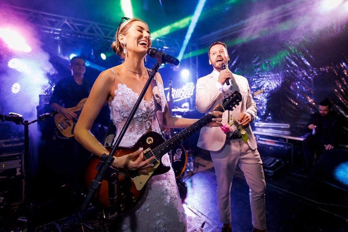 Noivos cantando e tocando guitarra na festa do casamento