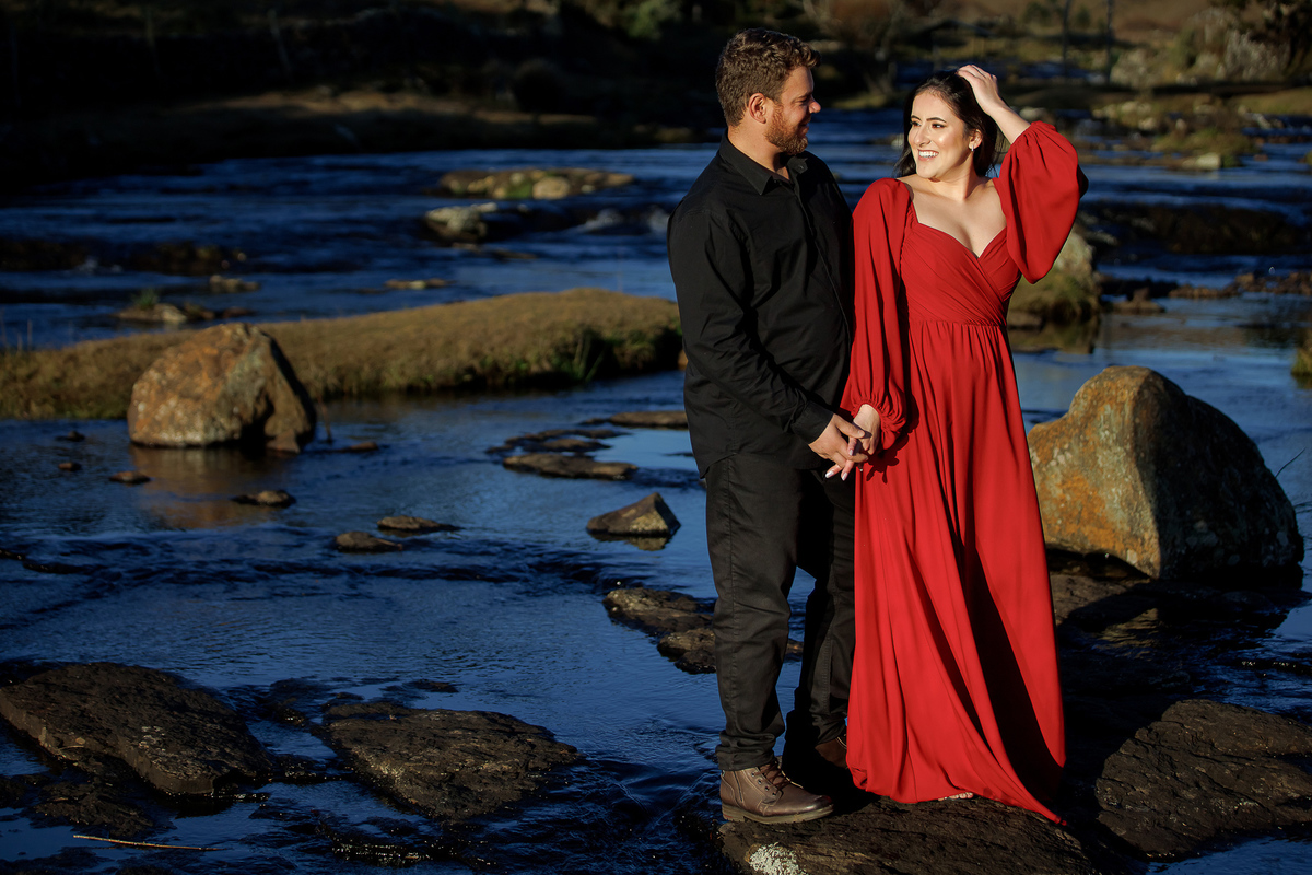 Casal na beira do rio com pedras e natureza exuberante.
Ensaio de casal aventureiro em meio à paisagem bruta de Bom Jardim da Serra.