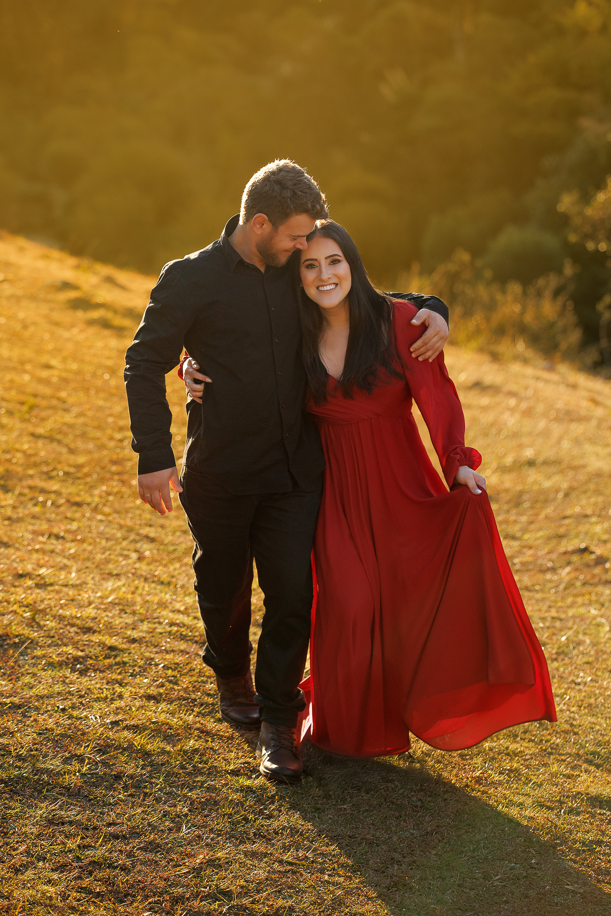 Casal de mãos dadas, noiva com vestido vermelho vibrante. ensaio pre-casamento