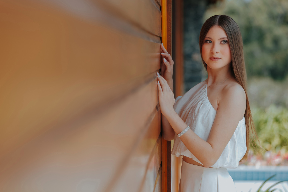 Encostada na parede de madeira, Laís combina delicadeza e atitude, mostrando a beleza das jovens de 15 anos em ensaios autênticos no interior de Santa Catarina.