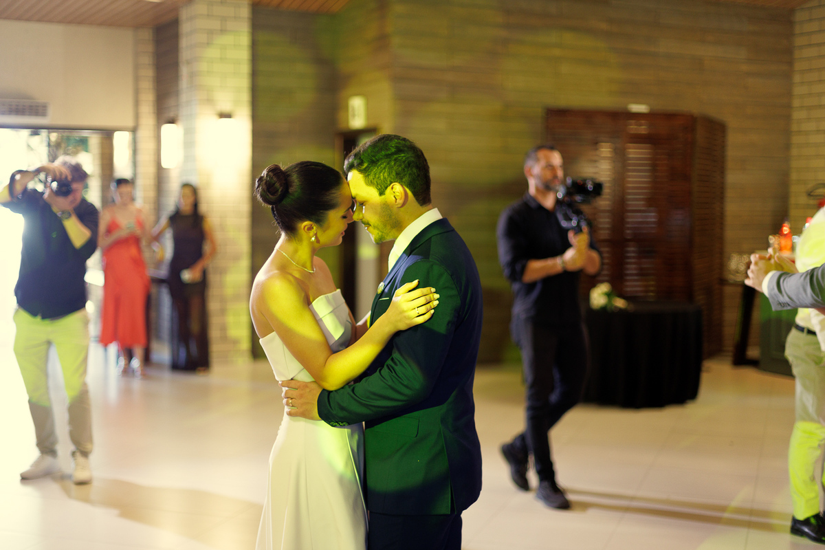 Noivos dançando sob as luzes da pista na festa de casamento.