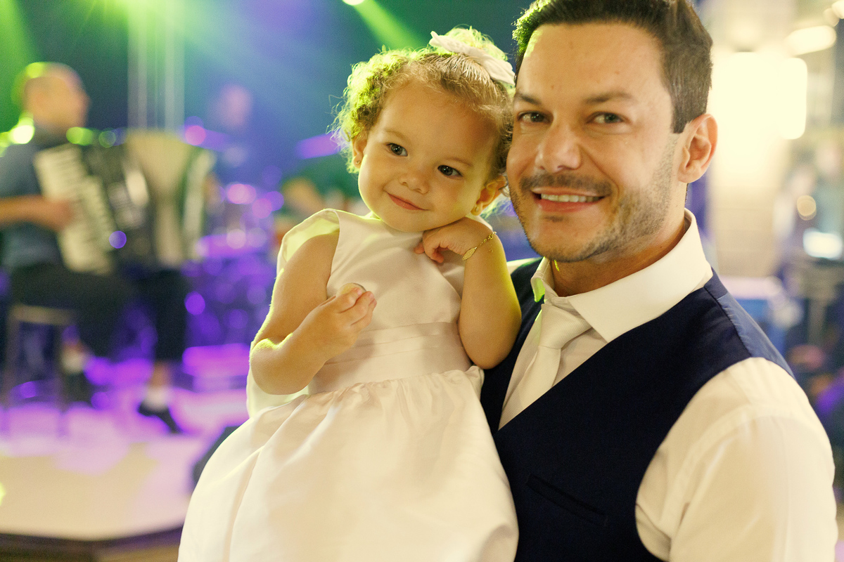 Noivo dançando com criança durante a festa de casamento na Cegero.