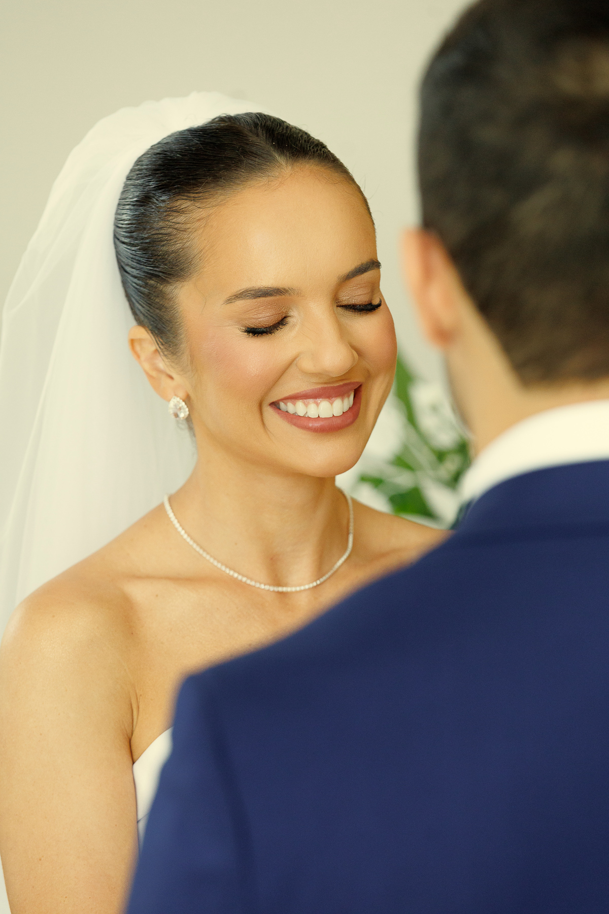 Noiva sorrindo emocionada durante a cerimônia de casamento.