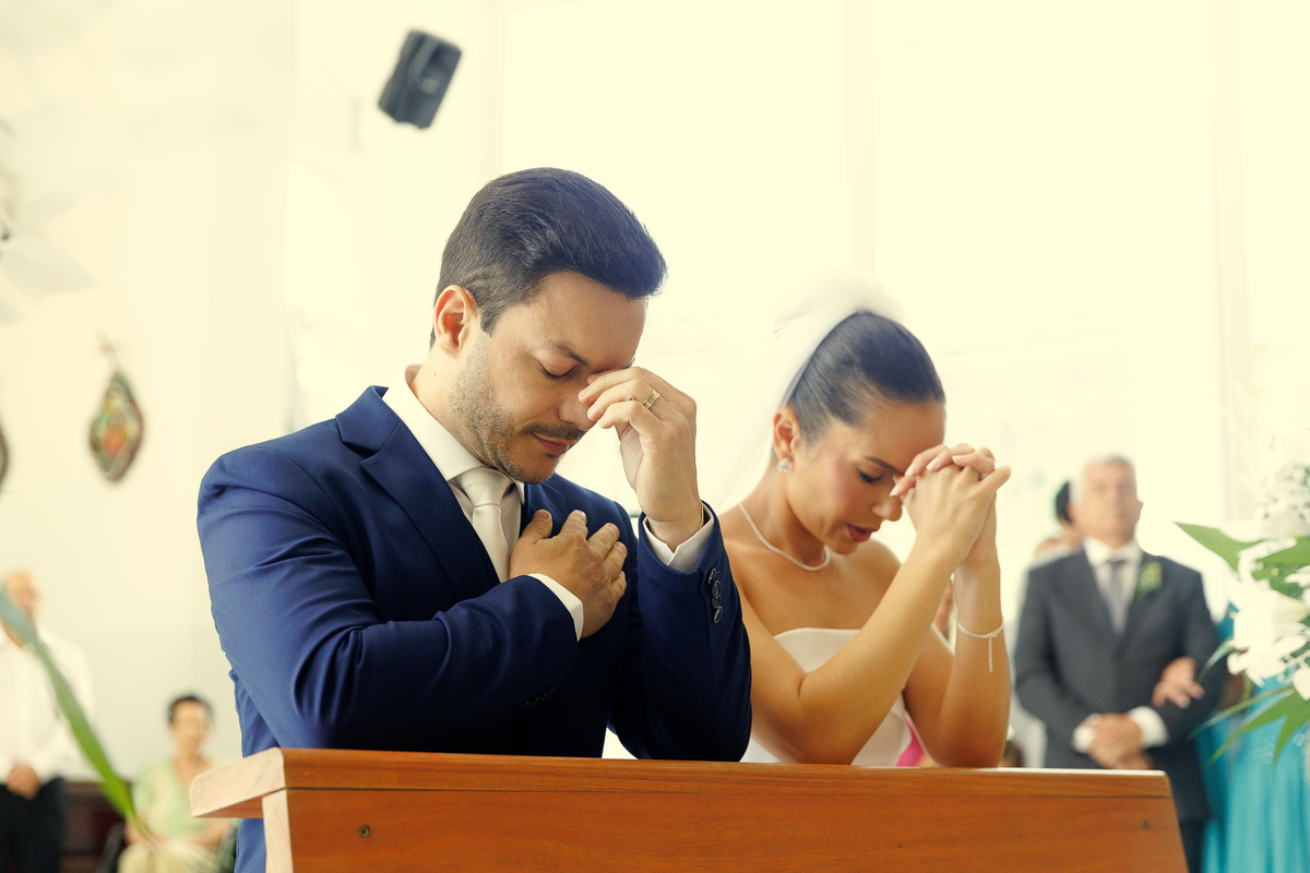 Noivos rezando durante a cerimônia religiosa de casamento.