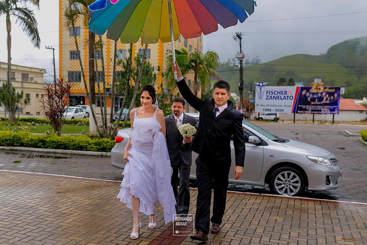 noiva saindo do carro com chuva