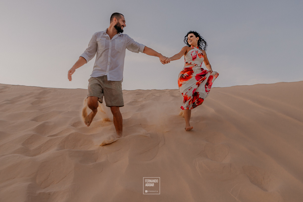 casal correndo feliz nas duas da praia