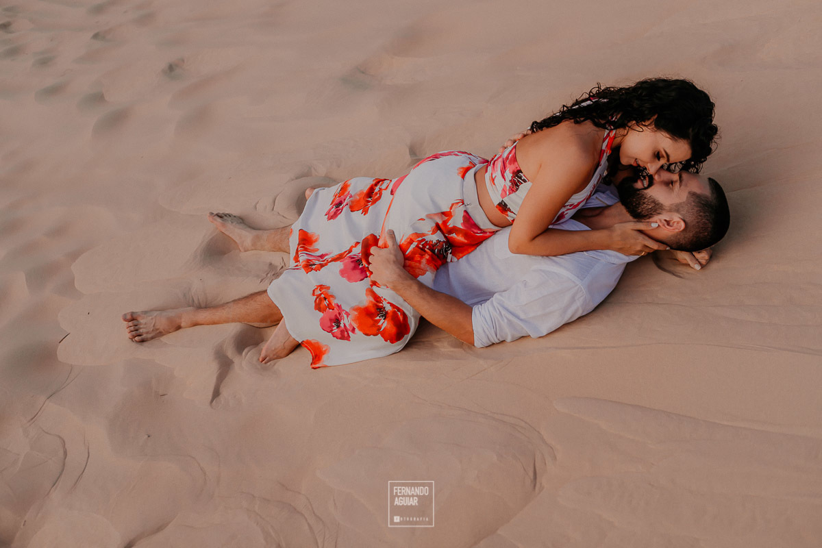 ensaio pre casamento casal se beijando deitado nas dunas da praia