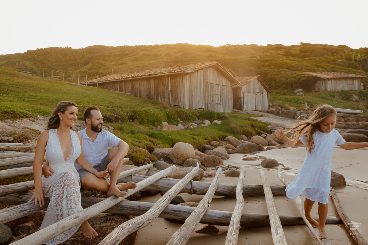 casal de noivo com a filha na praia 