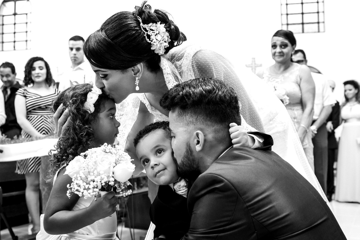 noivos beijam pajem e daminha durante a entrega das alianças casamento laudiceia e clayton