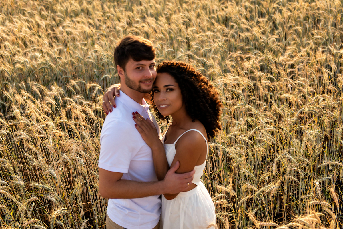casal abraçado em campo de trigo com o por do sol ao fundo em Holambra
