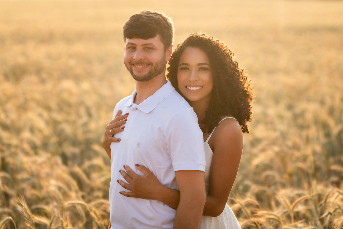 casal abraçado em campo de trigo com o por do sol ao fundo em Holambra