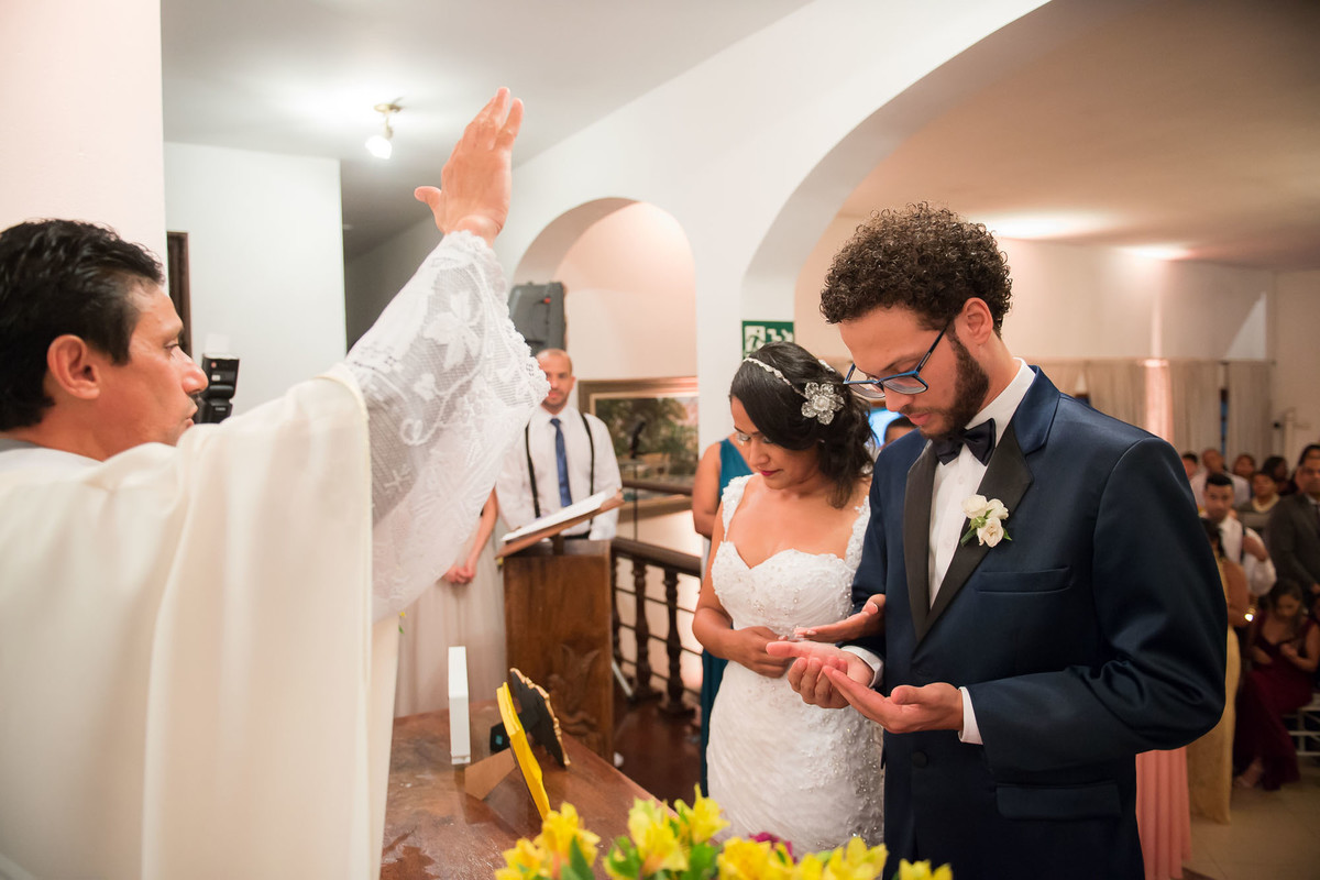 padre abençoa o casal durante a cerimonia