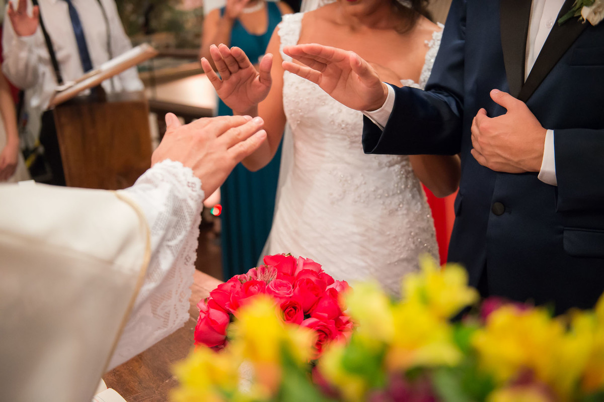 padre abençoa as alianças durante a cerimonia