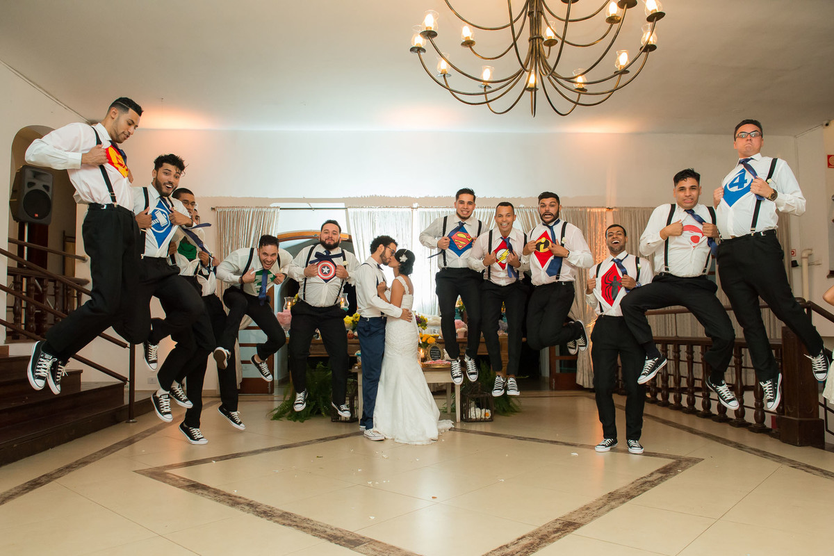 padrinhos pulando enquanto os noivos se beijam