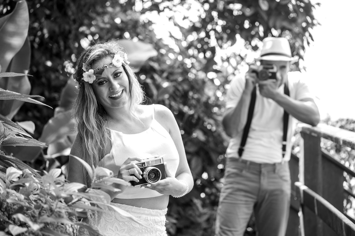 casal com camera fotografica na mão na praia do iporanga no guaruja