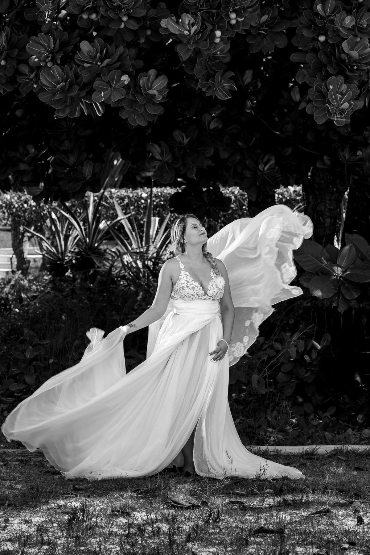 noiva com vestindo voando com o vento na praia do sao pedro no guaruja