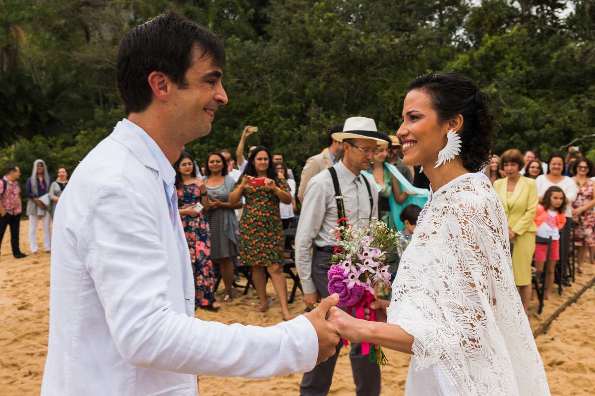 noivo recepcionando a noiva na beira da praia