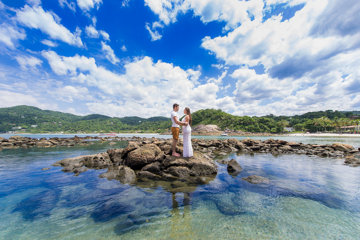 casal abraçados no meio do mar praia no guarujaense