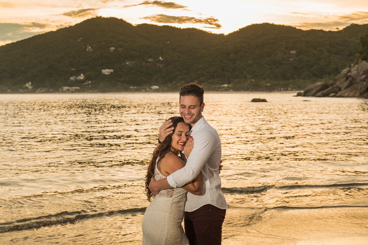 casal abraçados com o mar de fundo