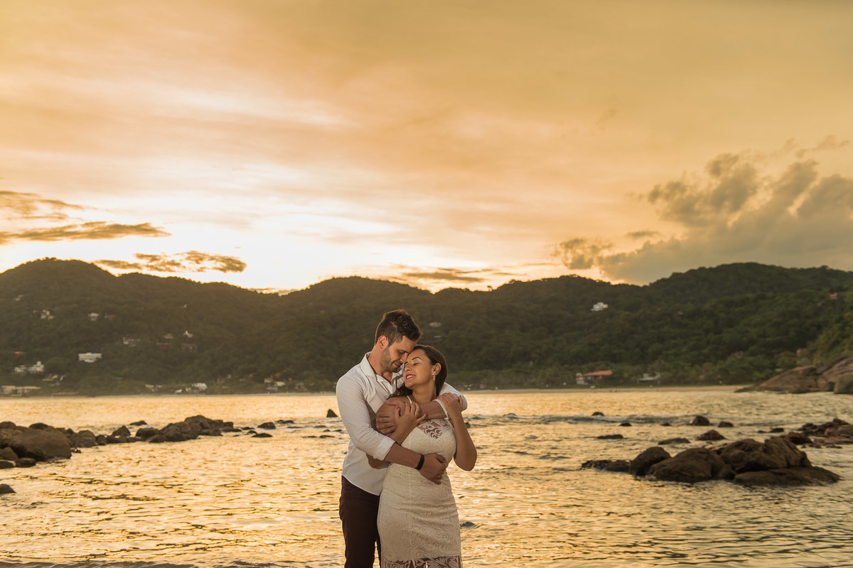 casal abraçados com o mar de fundo
