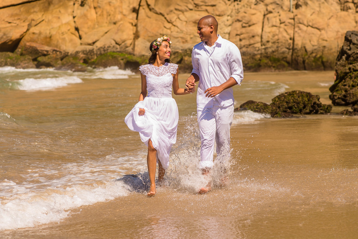 casal correndo na praia do meio em trindade paraty