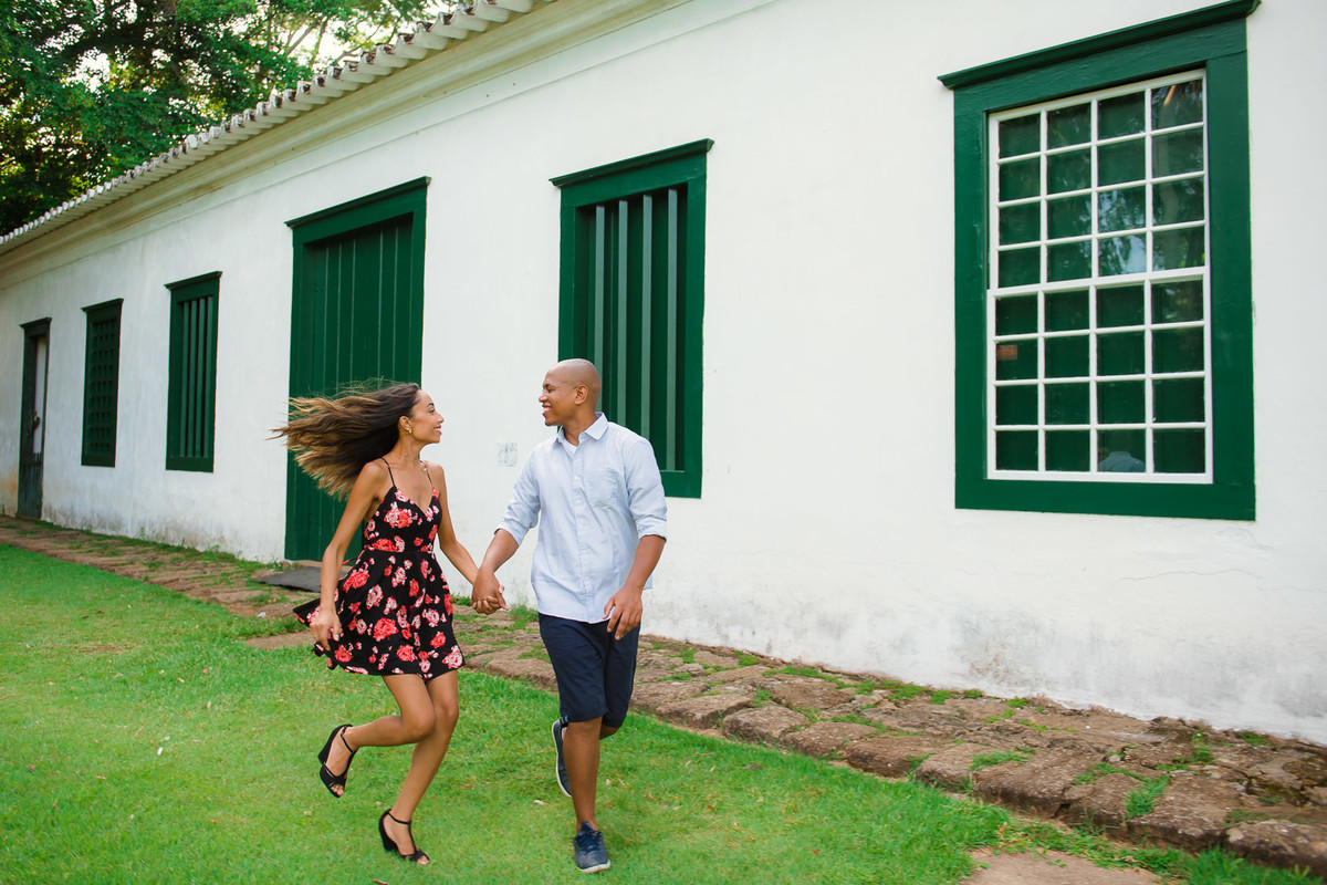 casal correndo de mãos dadas em paraty