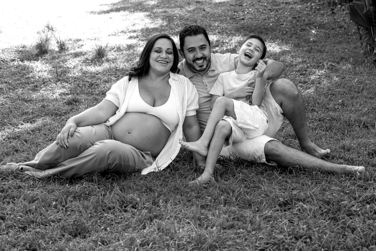 gestante e familia brincando na grama no parque vila lobos