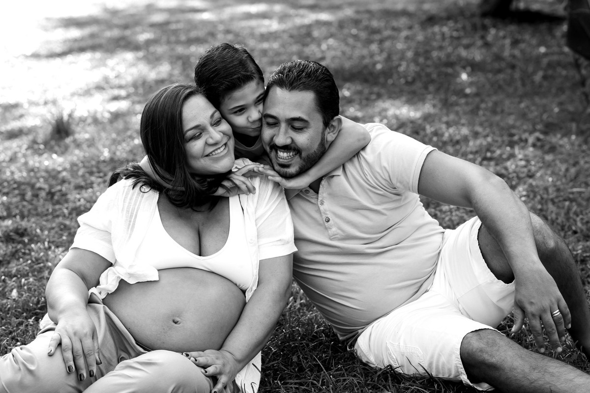 gestante e familia brincando na grama no parque vila lobos
